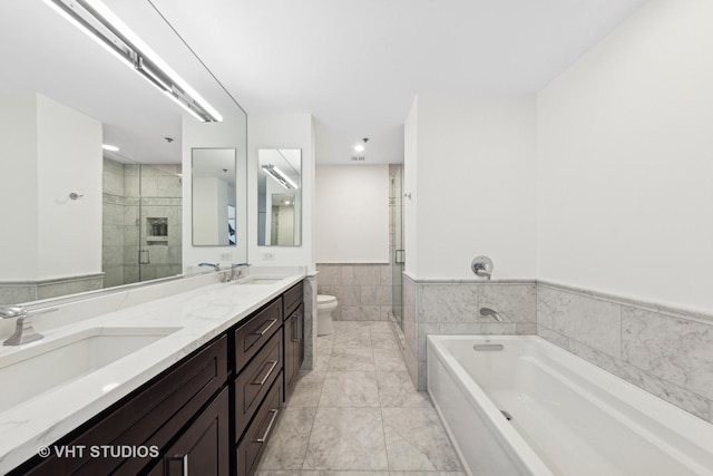 full bathroom with vanity, toilet, independent shower and bath, and tile walls