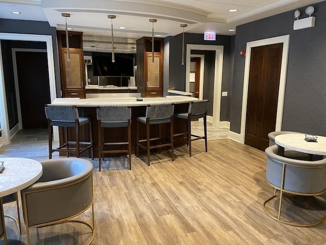 bar with pendant lighting and light hardwood / wood-style flooring