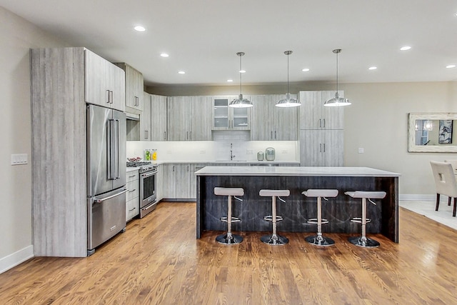 kitchen featuring a kitchen bar, decorative light fixtures, a center island, and premium appliances