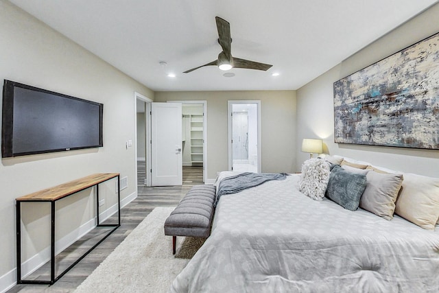 bedroom featuring ceiling fan, hardwood / wood-style floors, connected bathroom, a walk in closet, and a closet