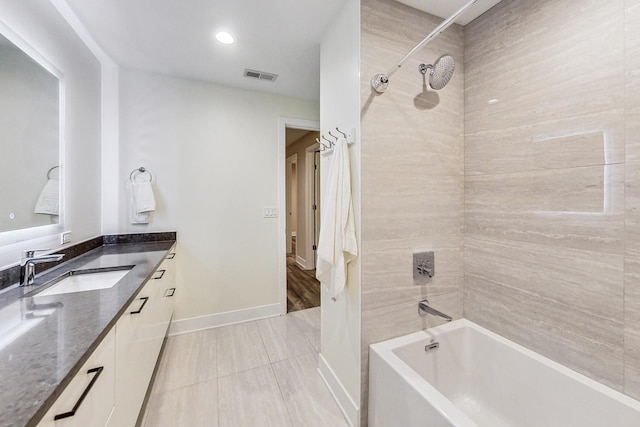 bathroom with vanity, tile patterned flooring, and tiled shower / bath