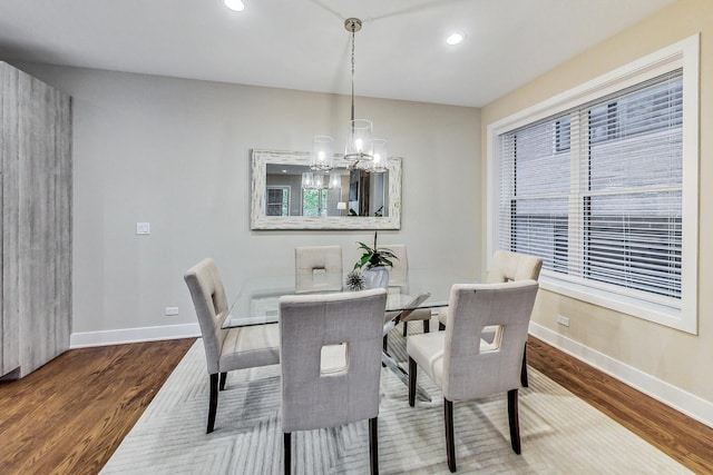 dining area with hardwood / wood-style flooring and a chandelier