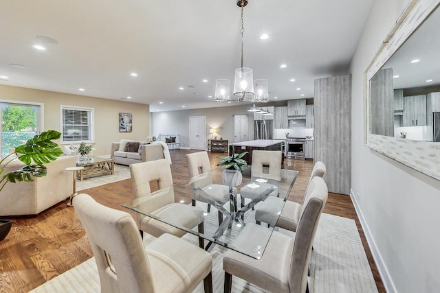 dining space with a notable chandelier and light wood-type flooring