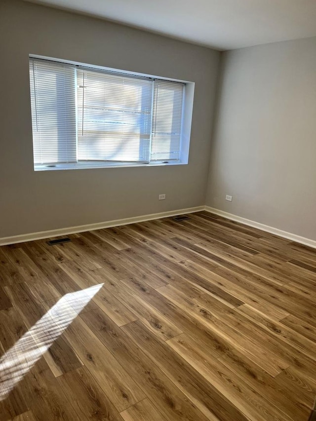 unfurnished room featuring wood-type flooring and plenty of natural light