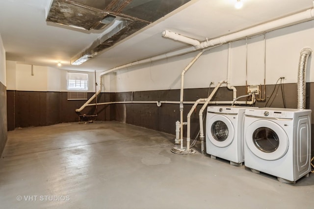 basement with separate washer and dryer and wood walls