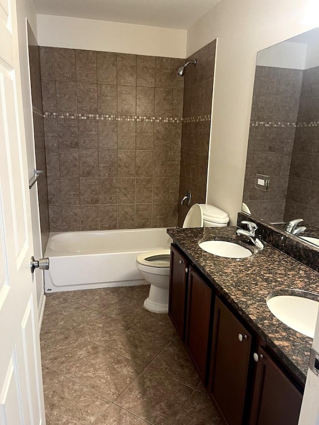 full bathroom with tile patterned floors, vanity, toilet, and tiled shower / bath combo