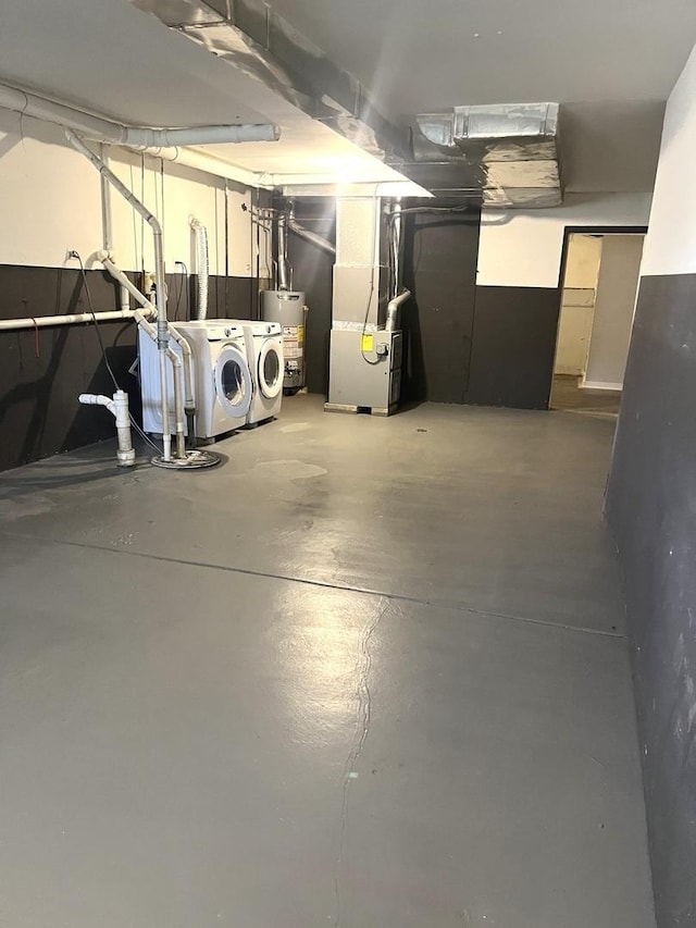 basement featuring gas water heater, heating unit, and washing machine and clothes dryer