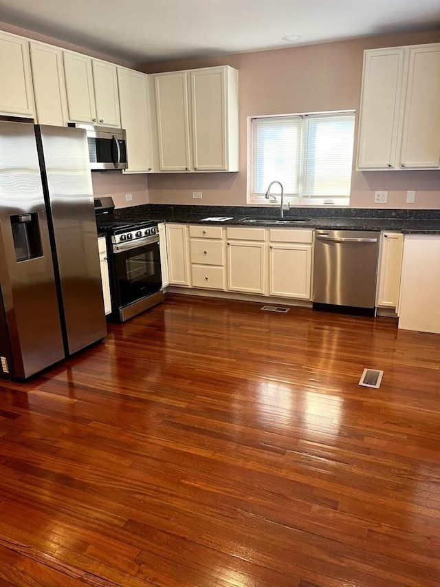 kitchen with white cabinetry, stainless steel appliances, dark hardwood / wood-style floors, and sink