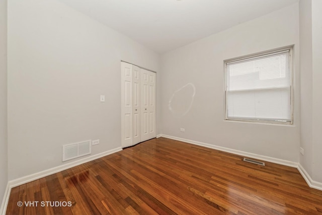 unfurnished bedroom featuring hardwood / wood-style floors and a closet