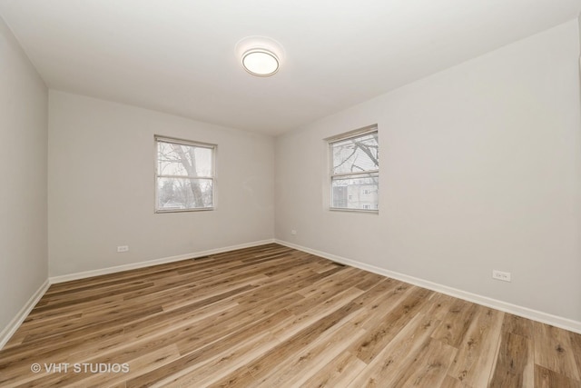 unfurnished room with a healthy amount of sunlight and wood-type flooring