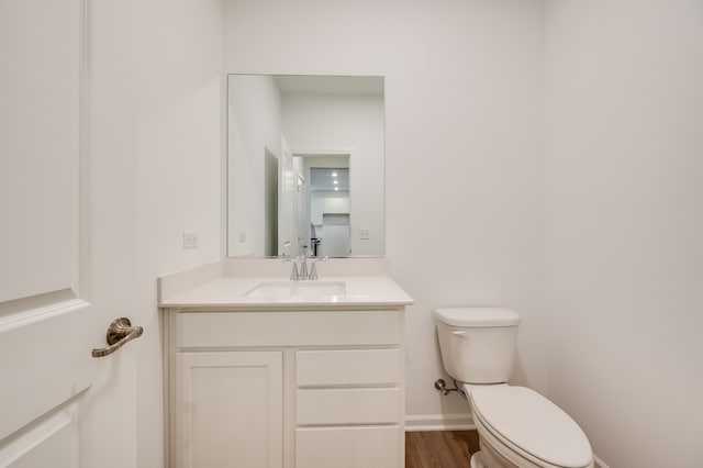 bathroom with hardwood / wood-style flooring, vanity, and toilet