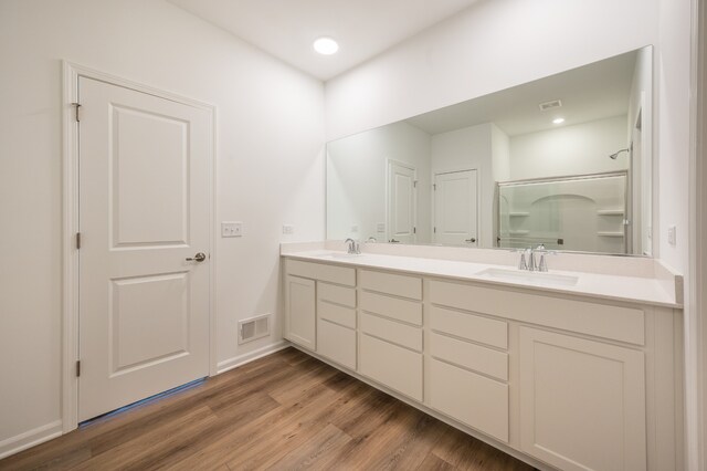 bathroom with vanity, hardwood / wood-style floors, and a shower with shower door