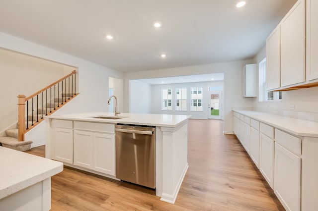 kitchen featuring sink, white cabinetry, a center island with sink, light wood-type flooring, and dishwasher