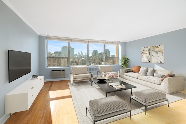 living room with crown molding, a wall unit AC, and light hardwood / wood-style floors