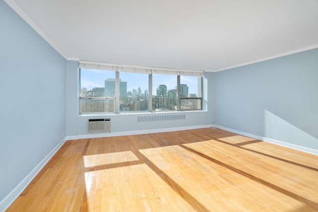 unfurnished room featuring crown molding, a wall mounted air conditioner, and light hardwood / wood-style flooring