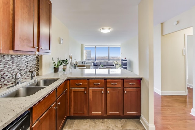 kitchen featuring sink, dishwasher, light stone countertops, decorative backsplash, and kitchen peninsula