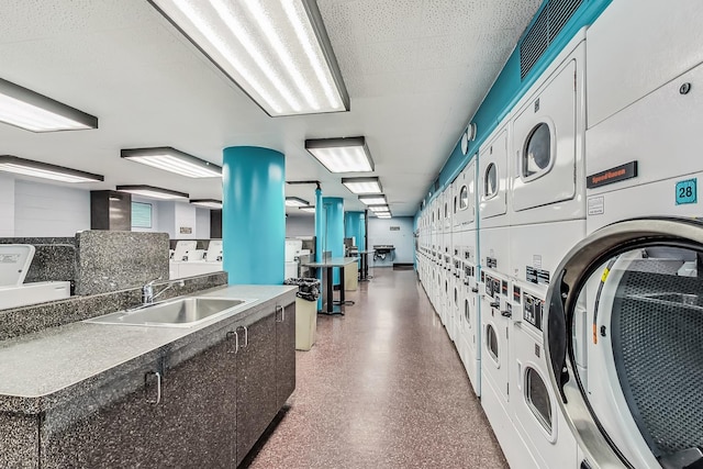 laundry room with stacked washer and dryer, sink, and washing machine and dryer