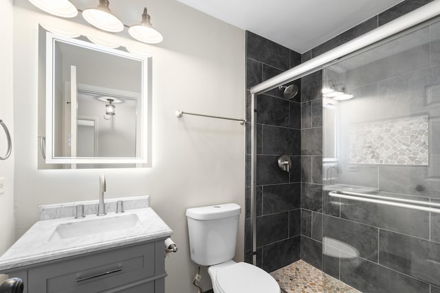 bathroom featuring vanity, toilet, and an enclosed shower