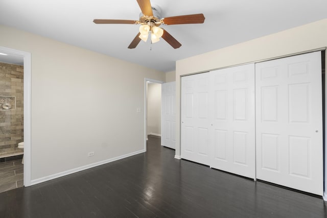 unfurnished bedroom featuring dark wood-type flooring, connected bathroom, ceiling fan, and a closet