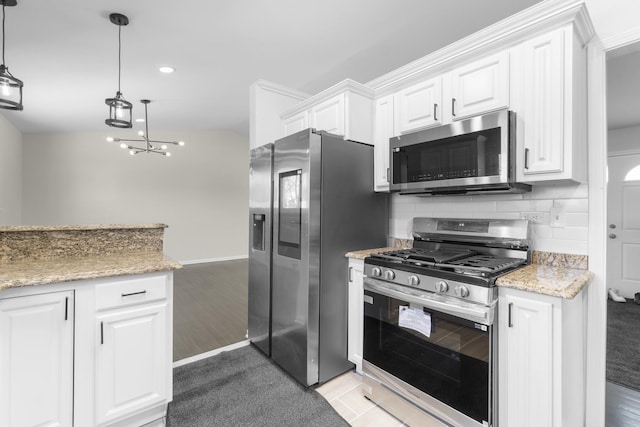 kitchen featuring tasteful backsplash, white cabinetry, appliances with stainless steel finishes, and pendant lighting