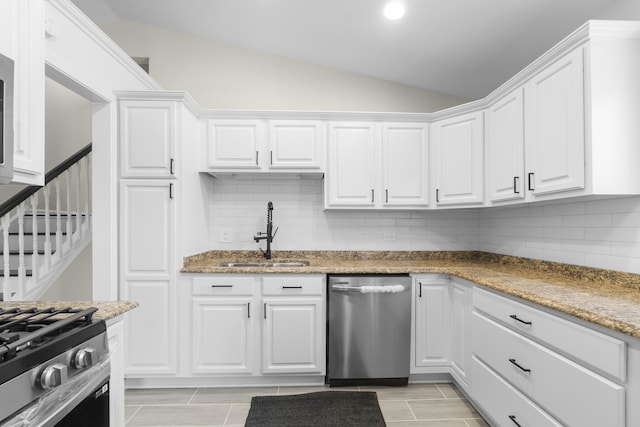 kitchen with stainless steel appliances, lofted ceiling, sink, and white cabinets