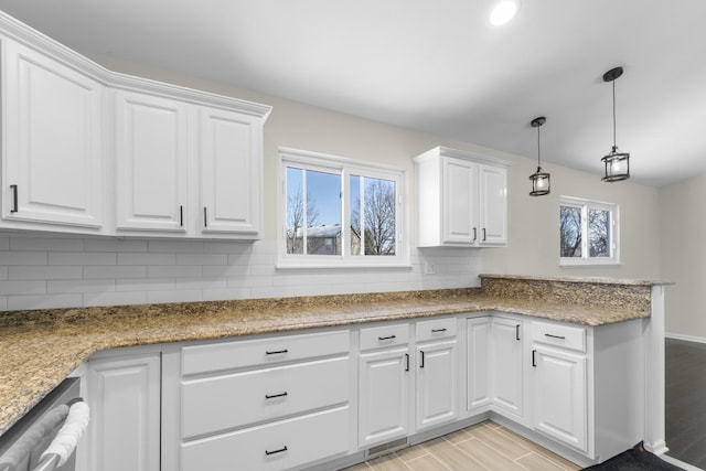 kitchen with stone countertops, dishwasher, pendant lighting, decorative backsplash, and white cabinets