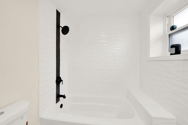 bathroom featuring tiled shower / bath and toilet