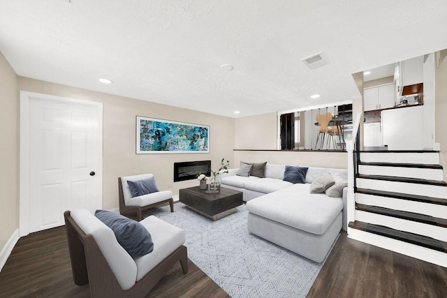 living room with dark hardwood / wood-style flooring and a textured ceiling