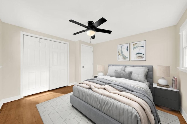 bedroom with ceiling fan, light wood-type flooring, and a closet