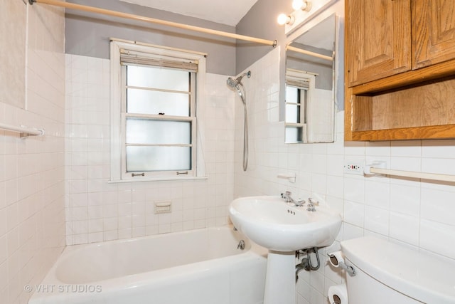 full bathroom featuring toilet, sink, tiled shower / bath, tile walls, and backsplash