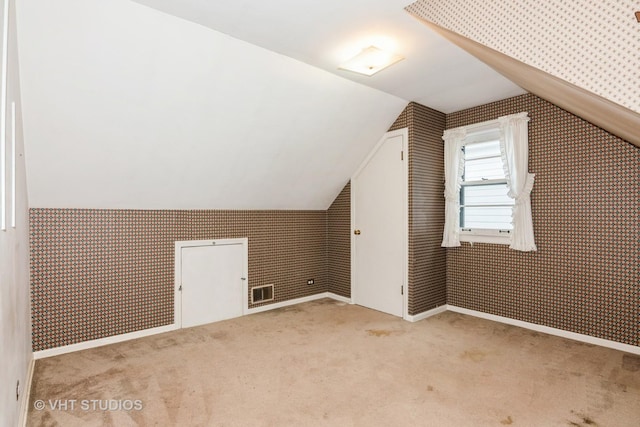 additional living space with lofted ceiling and light colored carpet