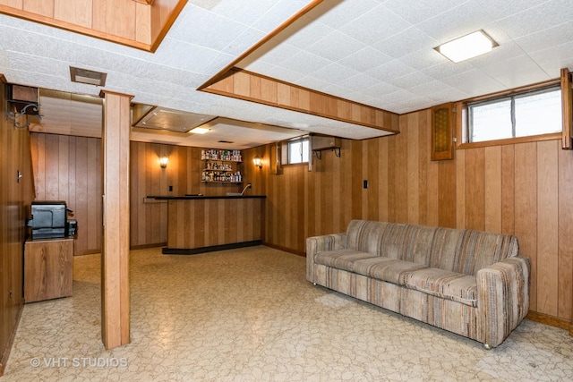 living room featuring bar and wood walls