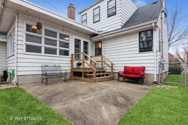 back of property with a yard and a patio area