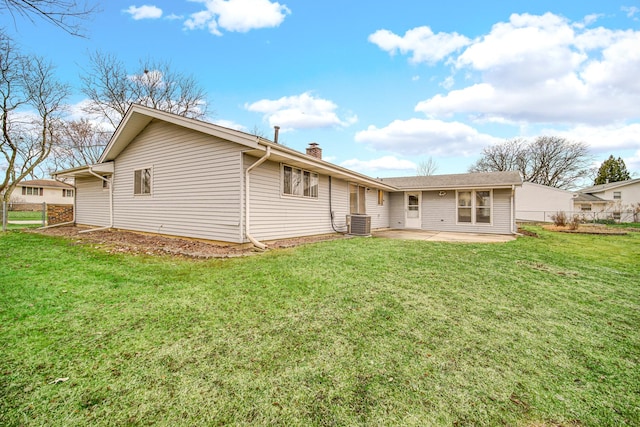 rear view of property with a yard, central AC unit, and a patio area