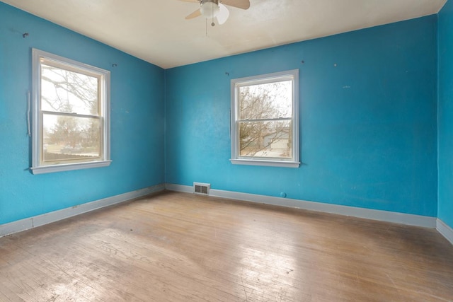 unfurnished room with plenty of natural light, ceiling fan, and light hardwood / wood-style flooring