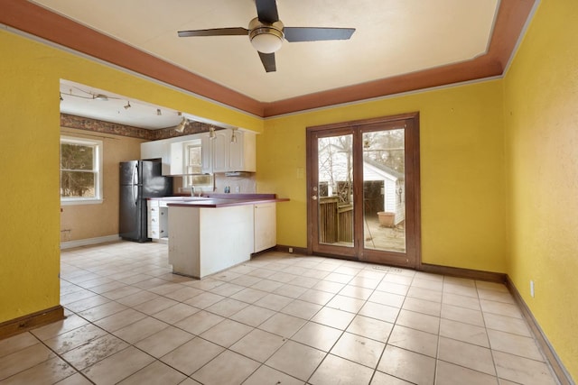 kitchen featuring black fridge, ceiling fan, white cabinets, light tile patterned flooring, and kitchen peninsula