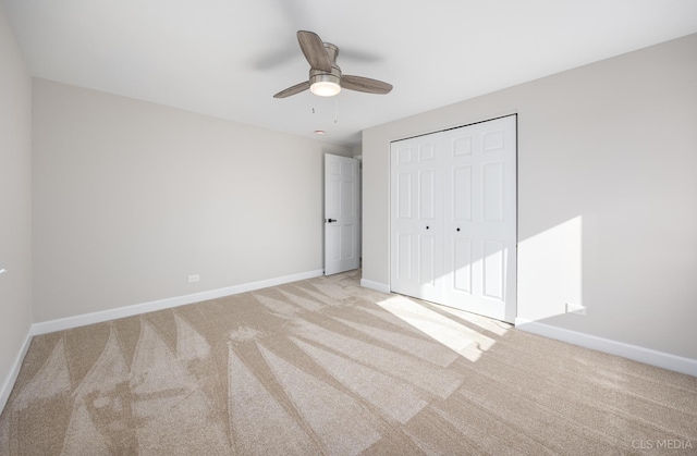 unfurnished bedroom featuring light colored carpet, a closet, and ceiling fan