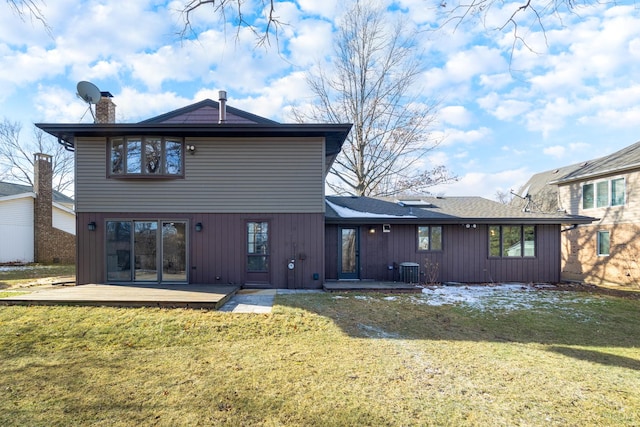 back of property with a yard and central AC