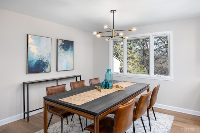 dining area with wood-type flooring and a chandelier