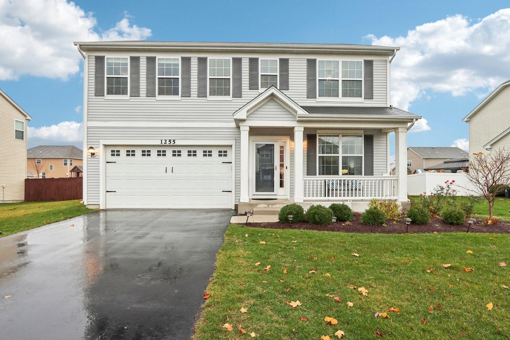 front of property featuring a porch, a garage, and a front yard