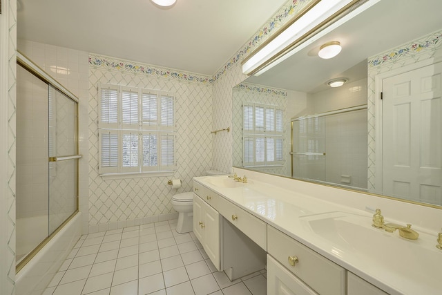 full bathroom with vanity, combined bath / shower with glass door, tile patterned floors, and toilet