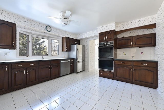 kitchen featuring decorative backsplash, light tile patterned floors, ceiling fan, stainless steel appliances, and dark brown cabinets