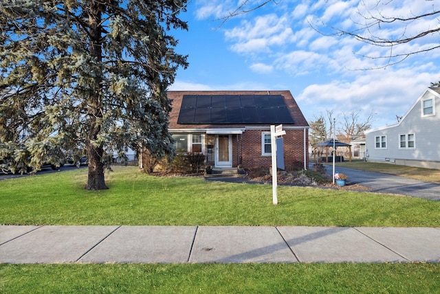 bungalow-style house with a front yard and solar panels