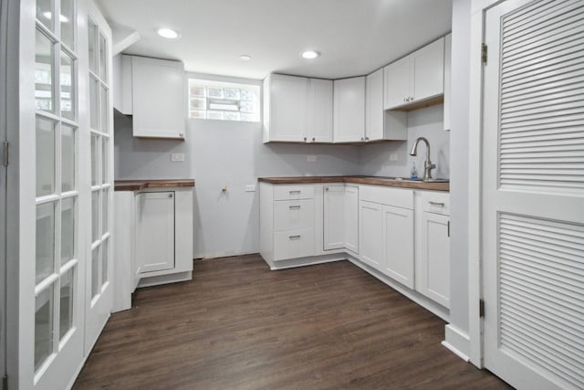 kitchen with dark hardwood / wood-style flooring, sink, white cabinets, and wood counters