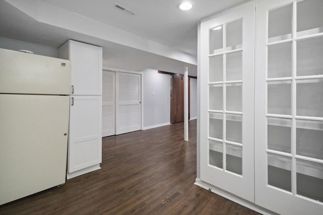 kitchen with white refrigerator, white cabinetry, and dark hardwood / wood-style floors