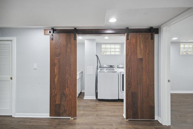 kitchen featuring washer and clothes dryer, a barn door, and wood-type flooring