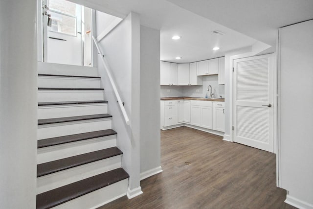 stairway featuring sink and wood-type flooring