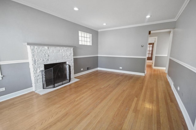 unfurnished living room featuring ornamental molding, a stone fireplace, and light hardwood / wood-style floors