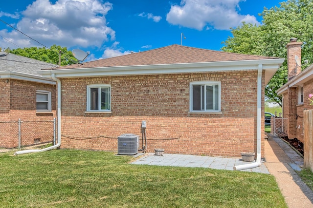 rear view of property with cooling unit and a yard