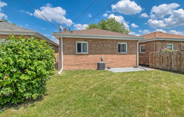 rear view of house with a yard and central air condition unit